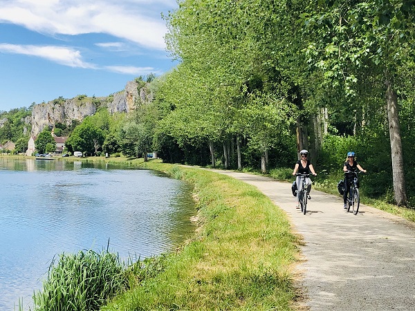 deux cyclistes au bord du canal du nivernais avec le rocher du saussois en arrière plan